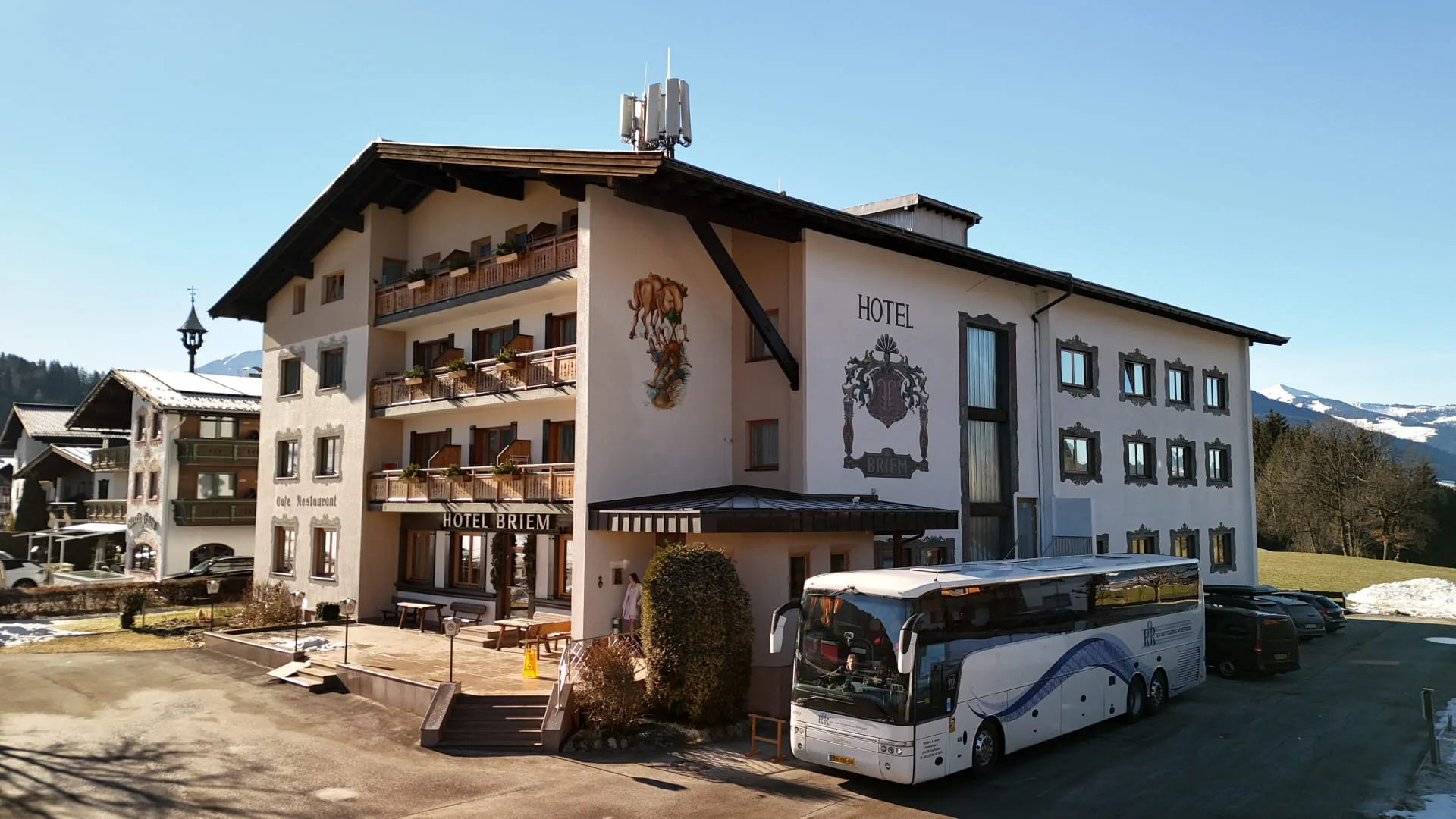 Hotel mit mehreren Etagen und Bus vor dem Eingang