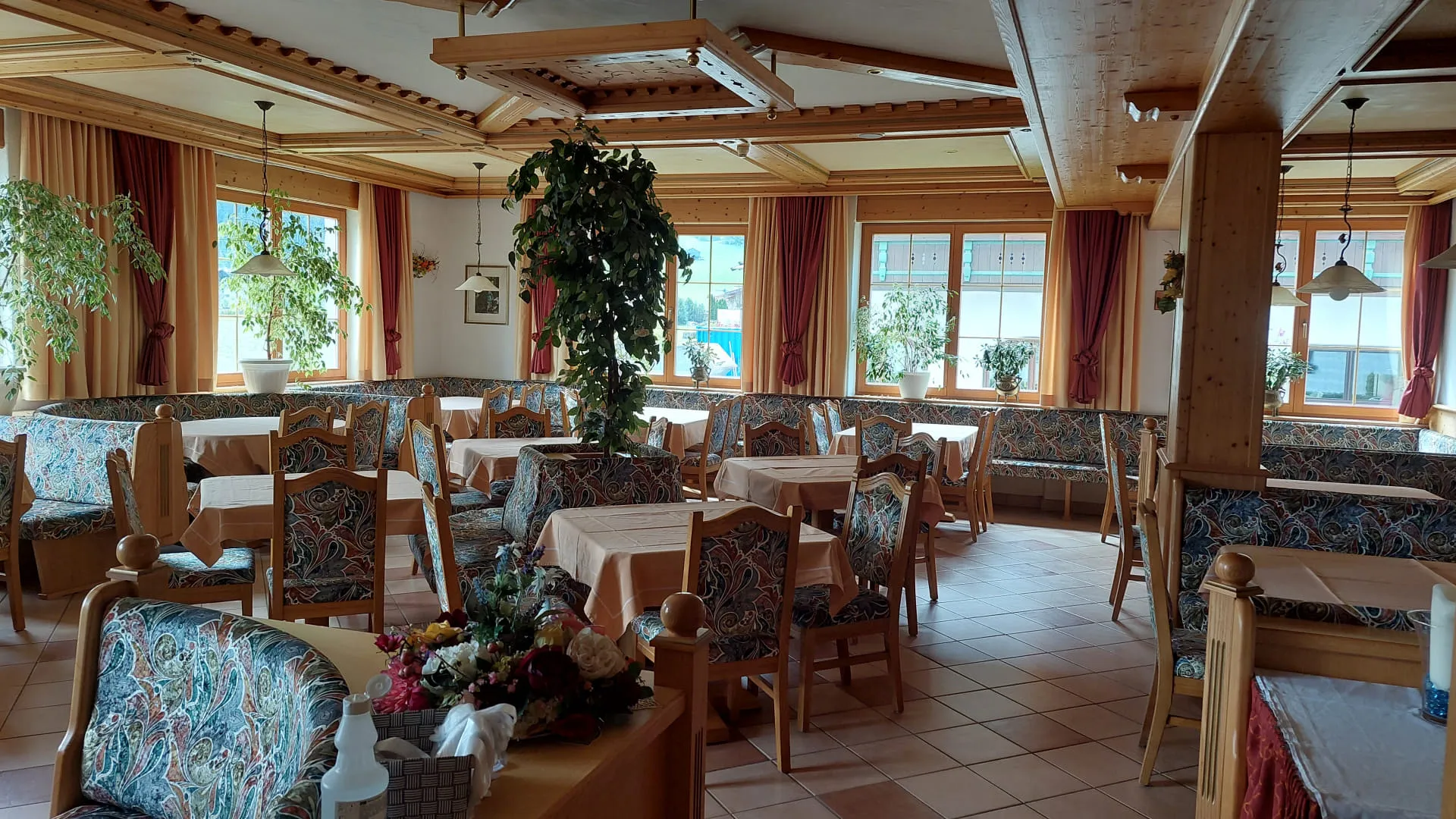 Innenansicht eines Restaurants mit Holzmöbeln und Pflanzen
