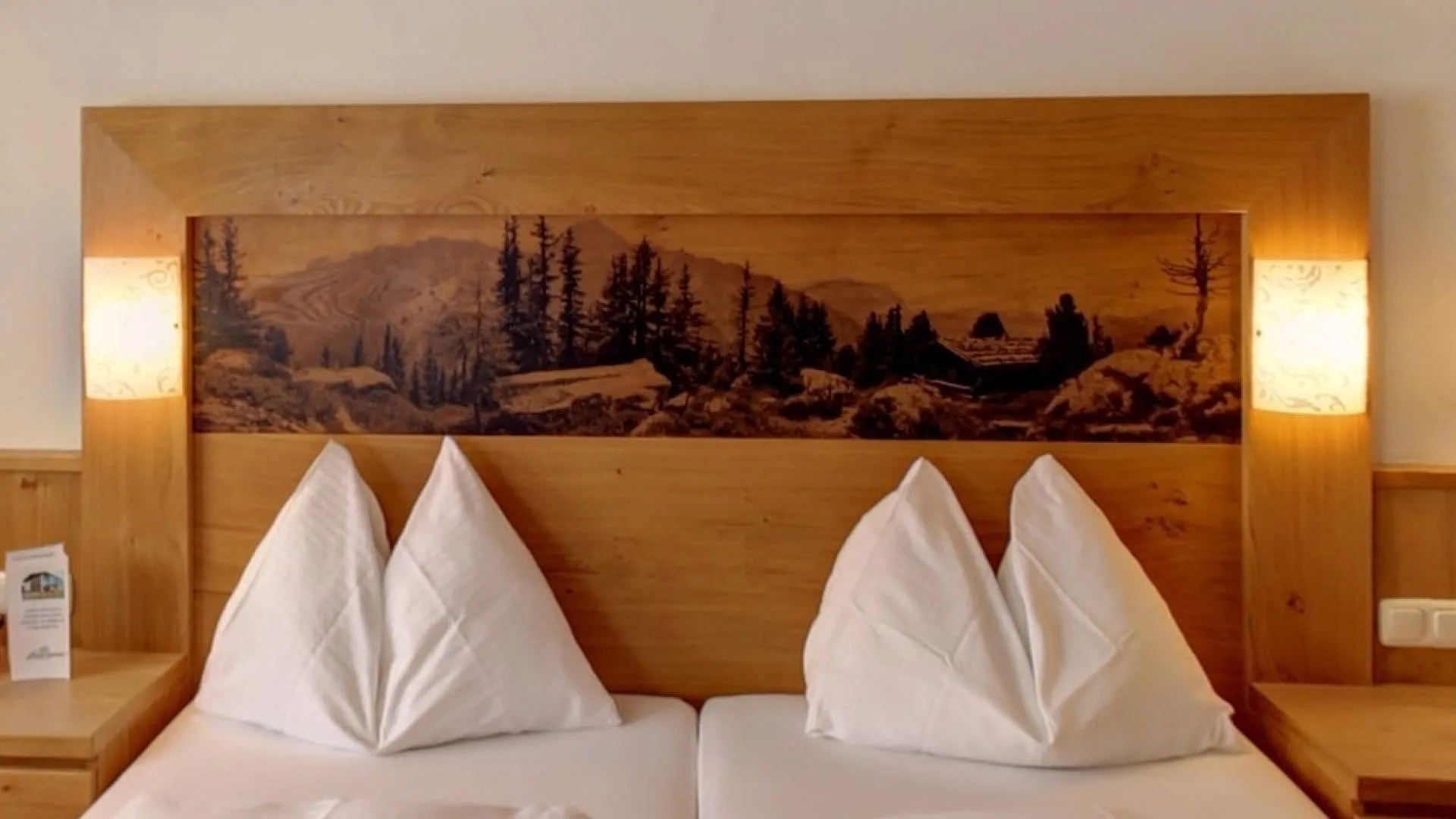 Doppelbett mit Holzpaneel und Berglandschaft im Hintergrund